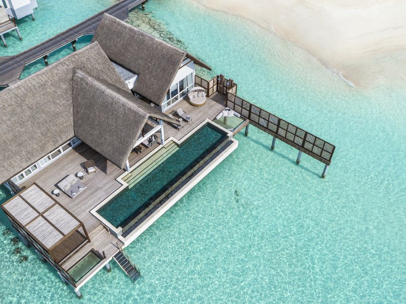 An overwater villa with its pool and walkway, from the air