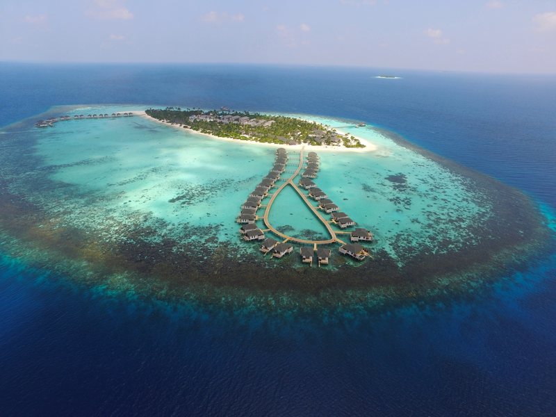 The island inside its ring of reef, with a loop of water villas