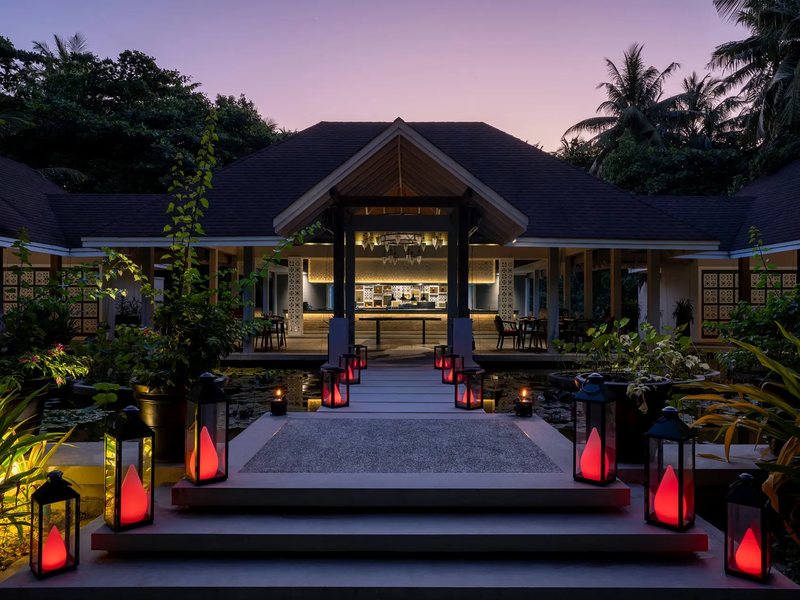 The lantern-lit entrance of the Battuta restaurant at dusk