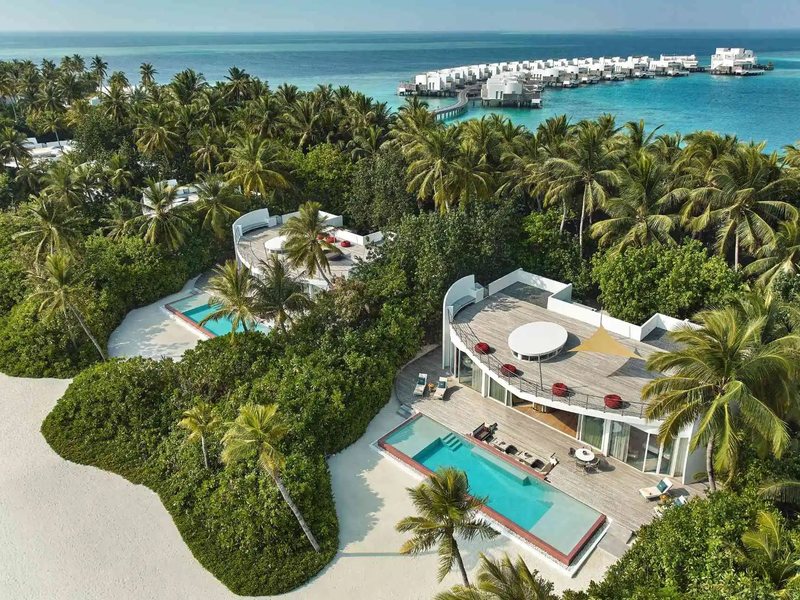Beach villas with pools among the palms, from the air