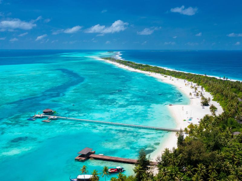 A long white beach and lagoon, with jetties