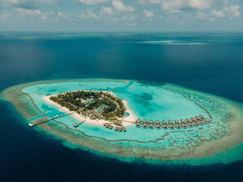 The island in its lagoon, with overwater villas, from high above