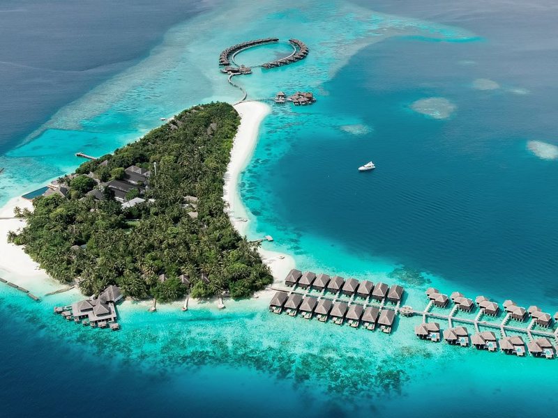 The island, its sandbank and rows of water villas, from the air