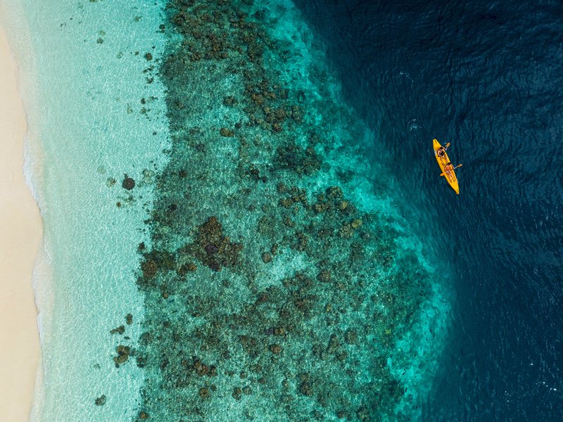 A kayak over the house reef just off the beach, from directly above