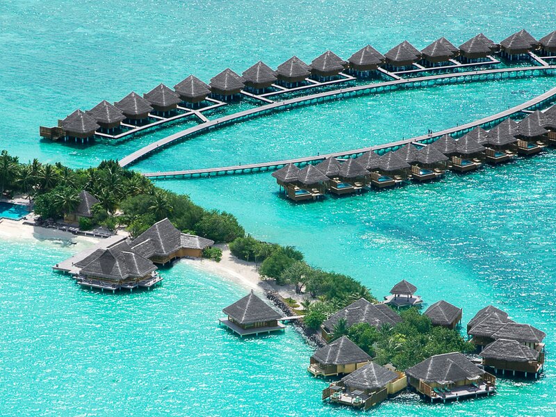 Loops of overwater villas beside the island, from the air