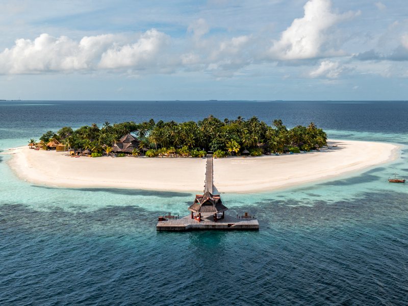The island, its broad white beach and jetty, from the air