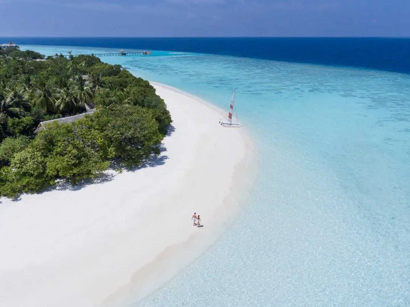 A white beach curving into a sandbank, from the air