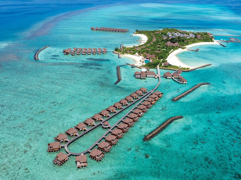 The island and its loops of overwater villas, from high above
