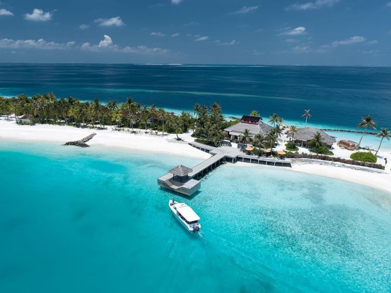 A beach and jetty, with a boat in the lagoon