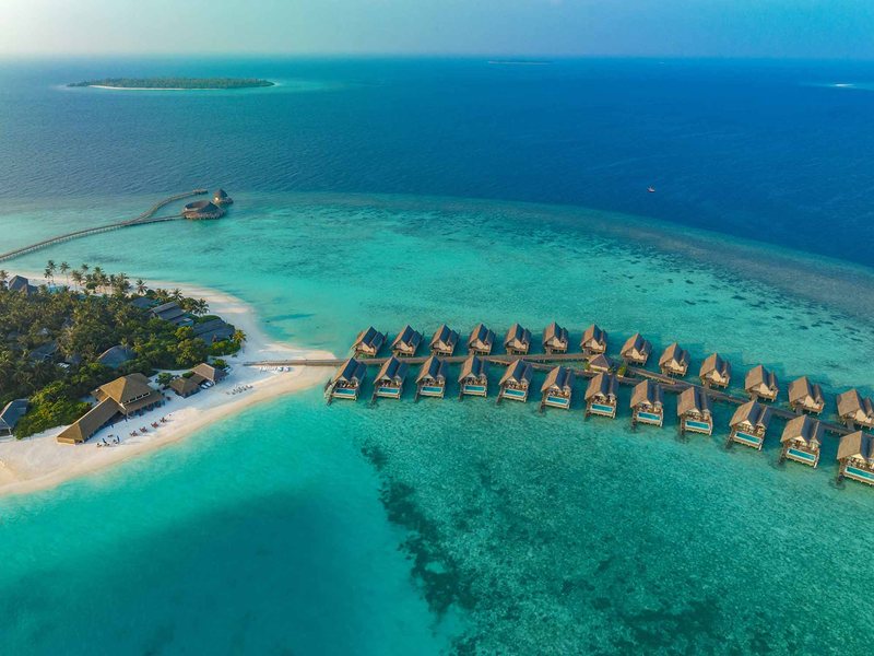 The island and its rows of overwater villas, from the air