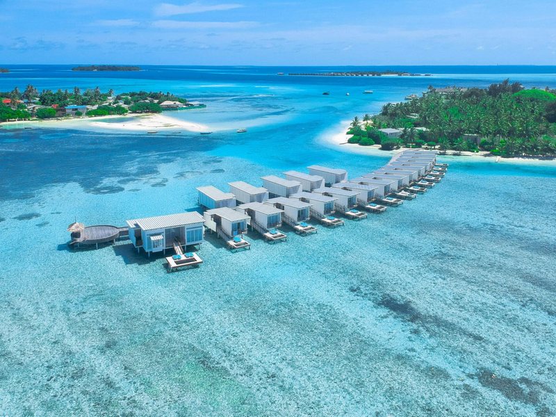 A curving row of white overwater villas, from the air
