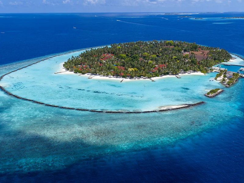 The island ringed by its reef and lagoon, from high above