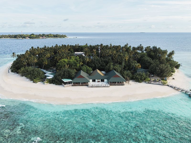 The small round island, its beach and jetty, from the air