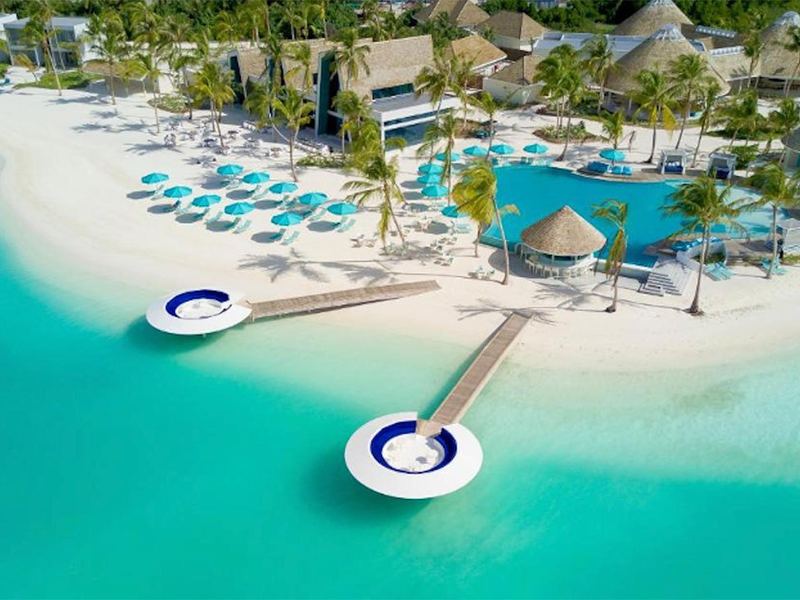 A pool and beach with sun loungers, from above