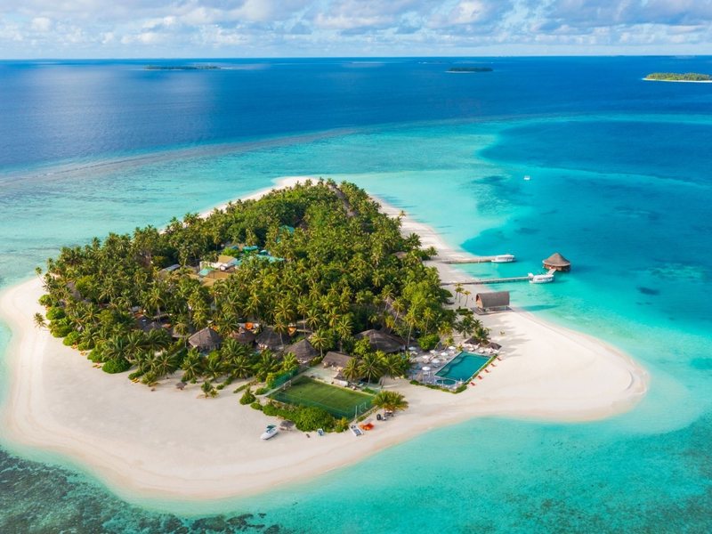 The round island, its beach and reef, from the air
