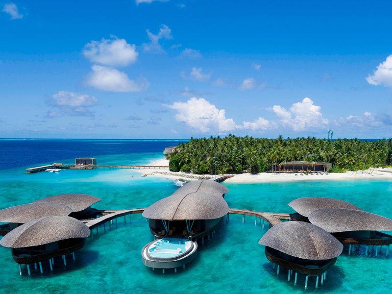 Overwater spa pavilions with domed roofs, the island behind