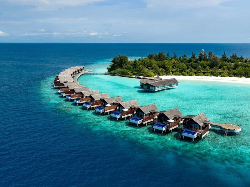 An arc of overwater villas off the island, from the air