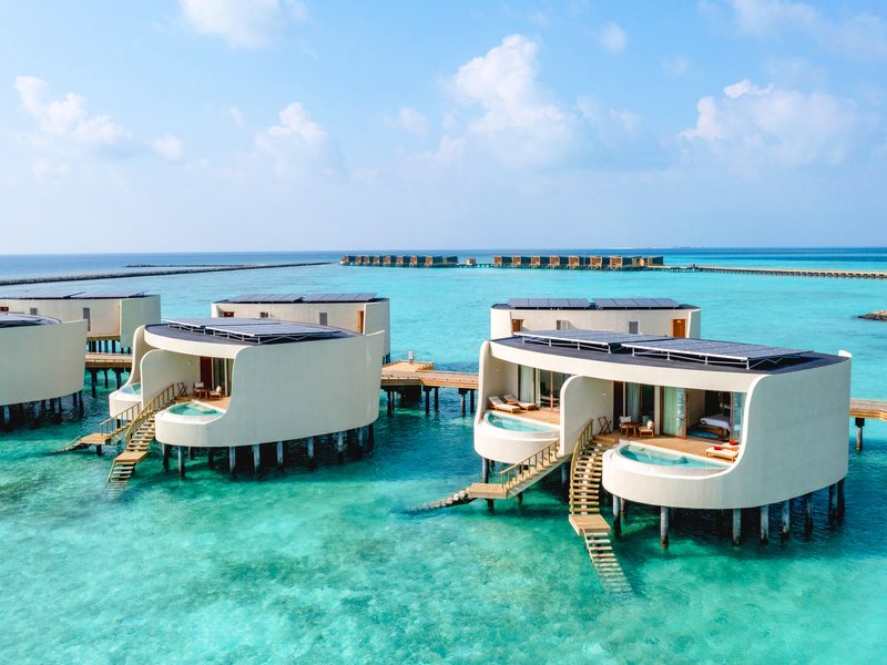 Overwater villas on stilts, with steps into the lagoon