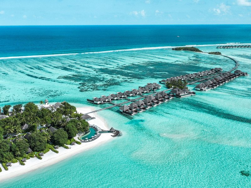 The island and its rows of overwater villas, from the air