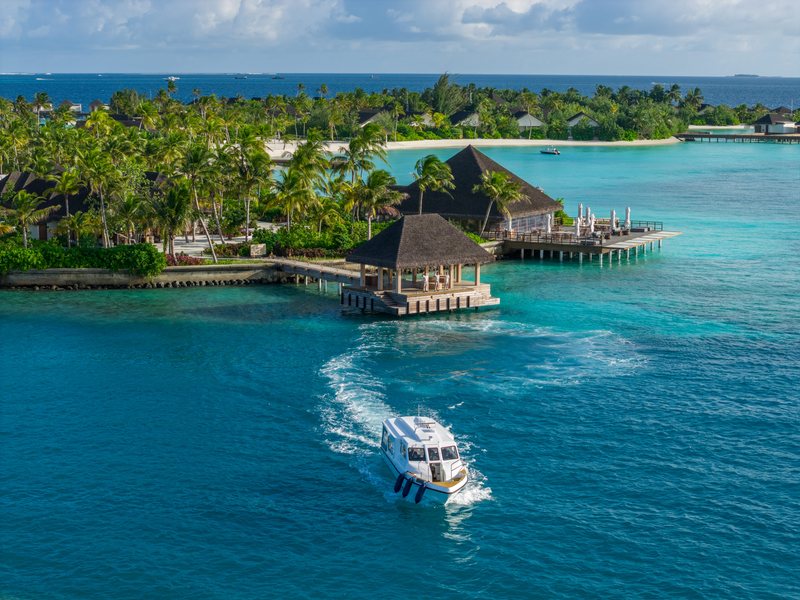 A speedboat leaving the resort jetty, from the air